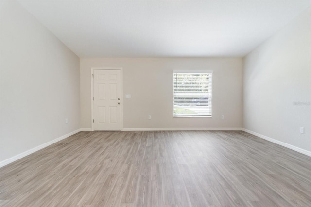 empty room with light wood-style flooring and baseboards