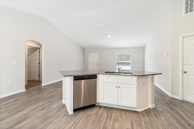 kitchen featuring dark stone counters, a sink, white cabinetry, dishwasher, and a center island with sink