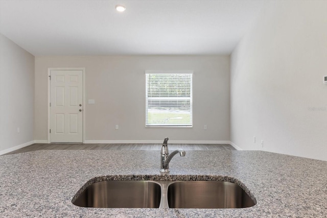 kitchen with light stone counters and a sink