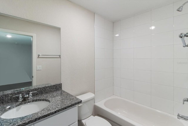 bathroom with toilet,  shower combination, a textured wall, and vanity