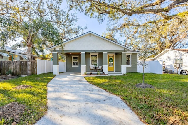 bungalow-style home with a porch, a front lawn, and fence