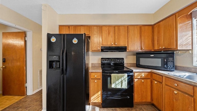 2453 Teri St, Auburndale, FL 33823 - kitchen featuring brown cabinets, light countertops, under cabinet range hood, and black appliances