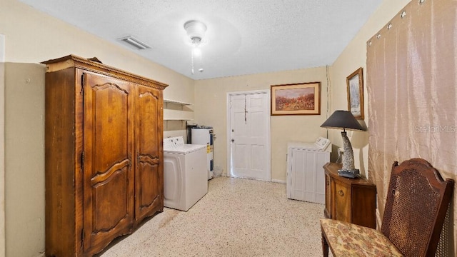 2453 Teri St, Auburndale, FL 33823 - laundry area featuring washer and clothes dryer, visible vents, water heater, a textured ceiling, and laundry area