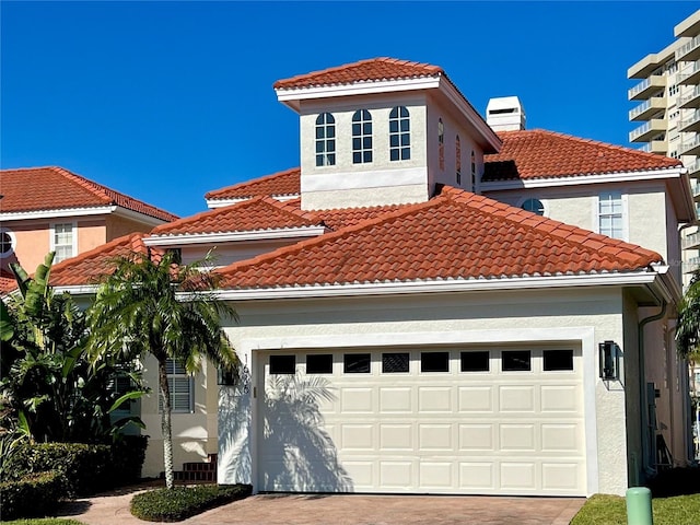 mediterranean / spanish-style home with a tiled roof and stucco siding