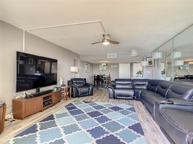 living area with visible vents, ceiling fan, and wood finished floors