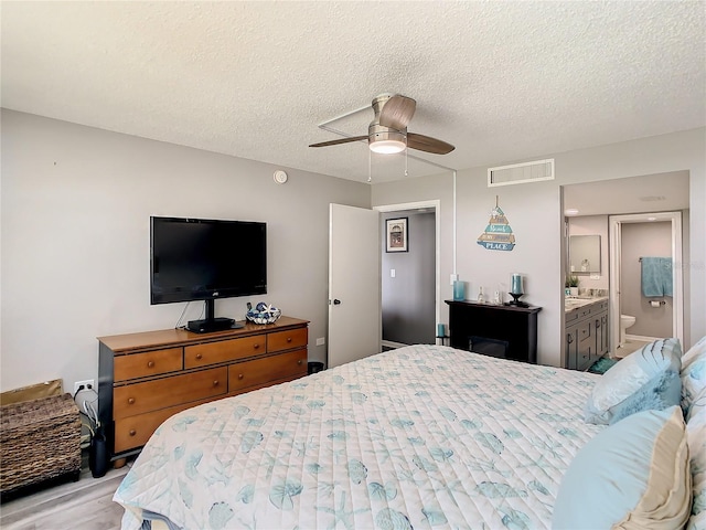 bedroom with visible vents, ceiling fan, a textured ceiling, and light wood finished floors