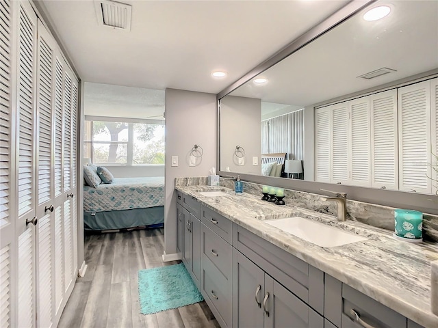 full bath with connected bathroom, a closet, a sink, and wood finished floors