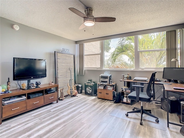 home office with ceiling fan, a textured ceiling, and light wood-type flooring