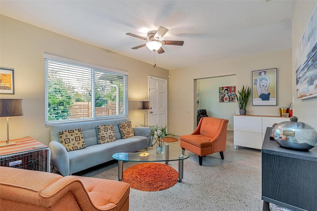 living room featuring ceiling fan and speckled floor