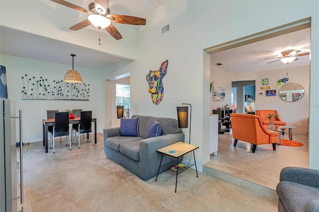 living area with a ceiling fan and visible vents