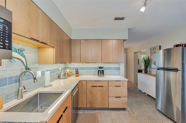 kitchen with stainless steel appliances, light countertops, a sink, and light brown cabinets