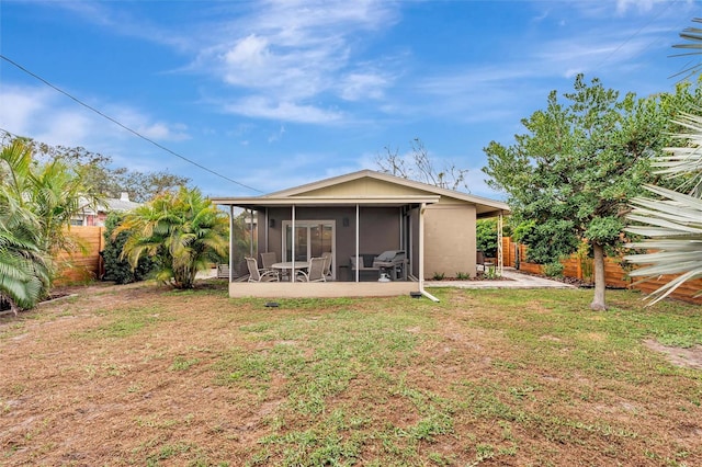 rear view of house featuring a sunroom, a fenced backyard, and a yard