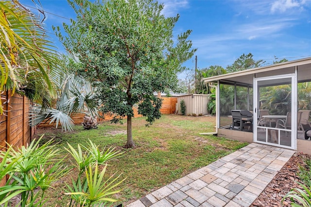 view of yard featuring a sunroom and a fenced backyard