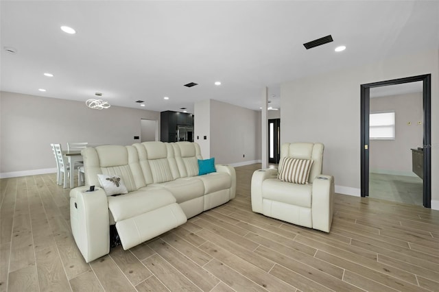 living room featuring light wood-type flooring, baseboards, and recessed lighting