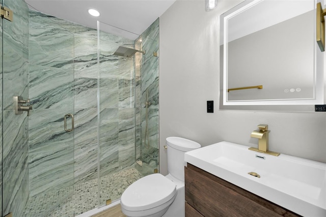 bathroom featuring a marble finish shower, vanity, and toilet