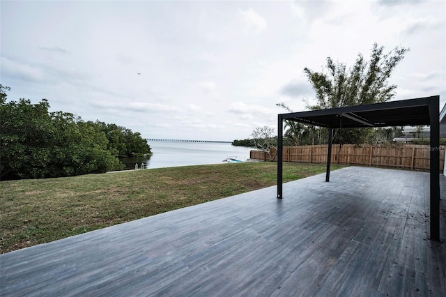 deck featuring a water view, fence, and a yard