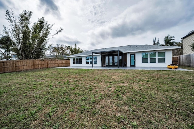 rear view of house featuring a yard, a fenced backyard, a patio, and stucco siding