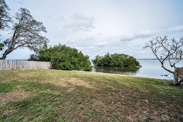 view of yard with a water view and fence