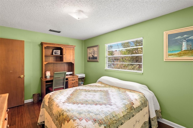 bedroom with visible vents, dark wood finished floors, a textured ceiling, and baseboards