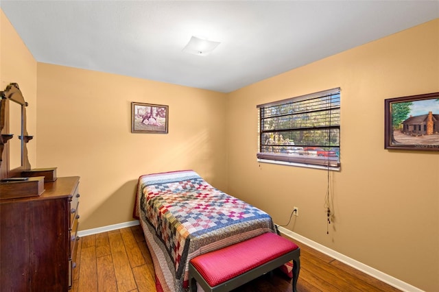 bedroom featuring wood finished floors and baseboards