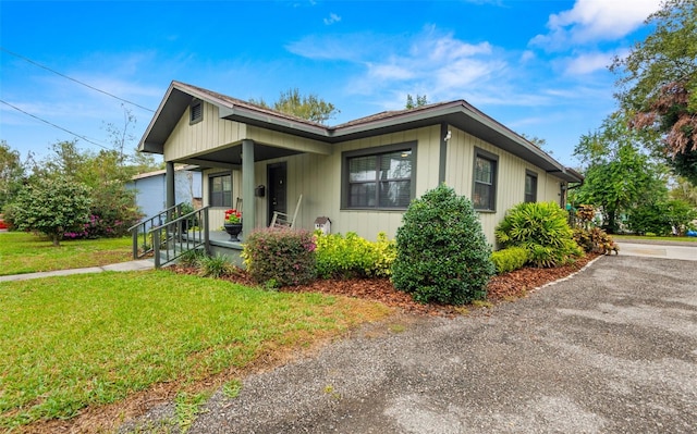 bungalow-style home with covered porch and a front yard