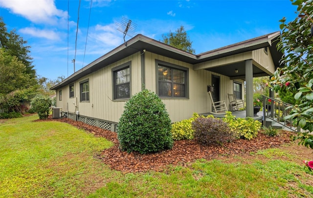 view of property exterior featuring a lawn, central AC unit, and covered porch