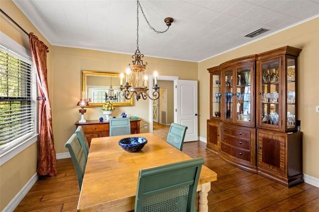 dining area featuring baseboards, dark wood-style flooring, visible vents, a chandelier, and crown molding