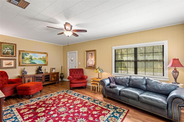 living area featuring visible vents, ceiling fan, and wood finished floors