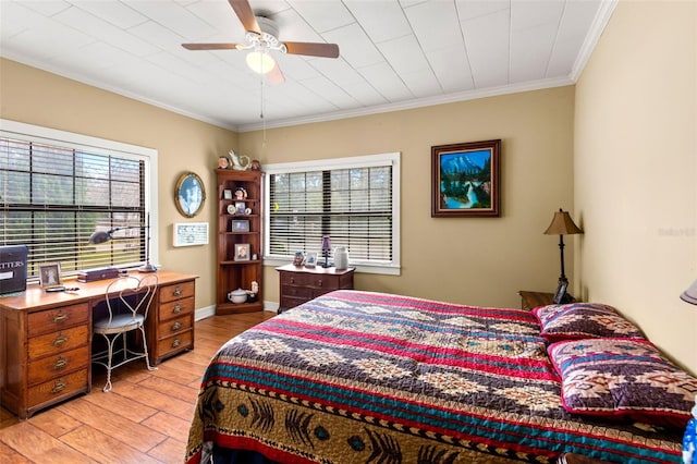 bedroom featuring crown molding, baseboards, light wood-type flooring, and a ceiling fan