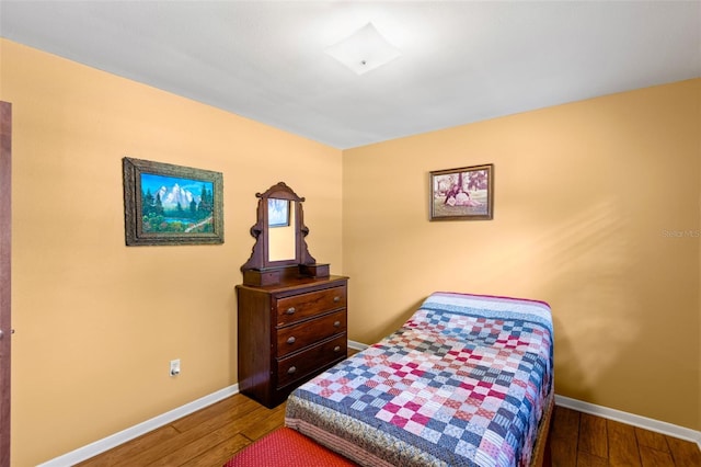 bedroom with baseboards and wood finished floors