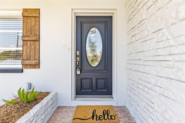 entrance to property featuring stucco siding