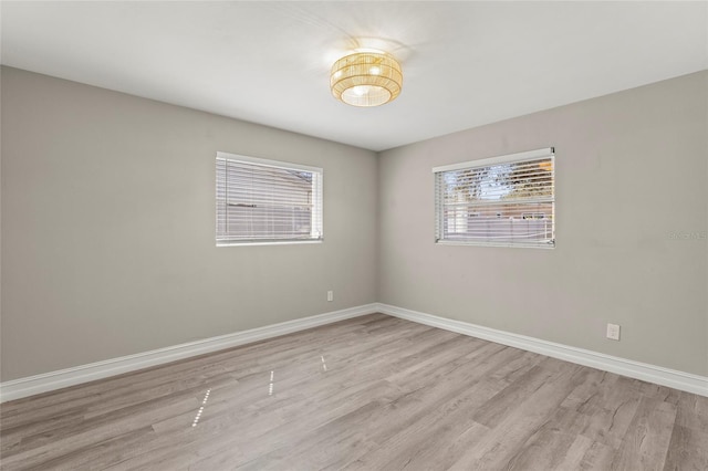 spare room with light wood-type flooring and baseboards