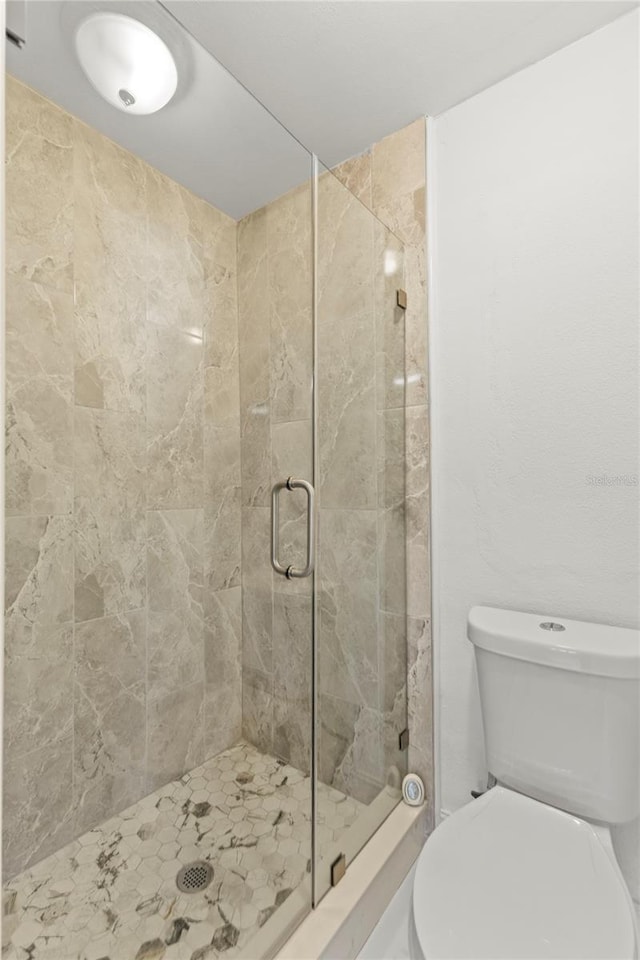 full bath featuring toilet and a stall shower