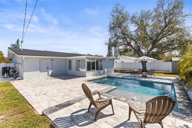 view of pool with a patio area, a fenced backyard, a sunroom, and a fenced in pool