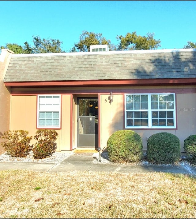 entrance to property featuring a shingled roof