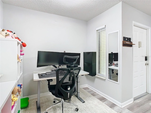 office with a textured ceiling, baseboards, and wood finished floors