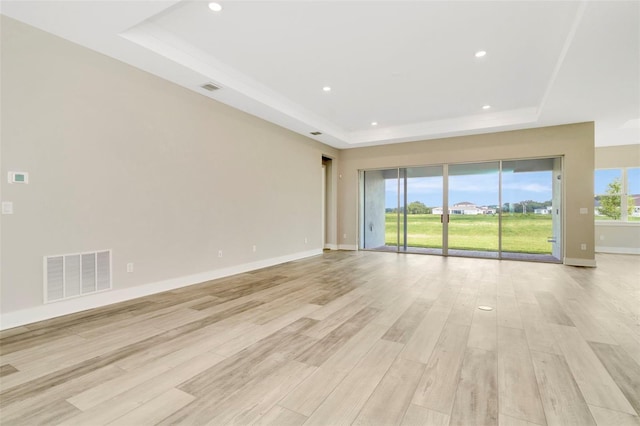 10714 Torchwood Sea Way, San Antonio, FL 33576 - empty room with light wood finished floors, a raised ceiling, and visible vents