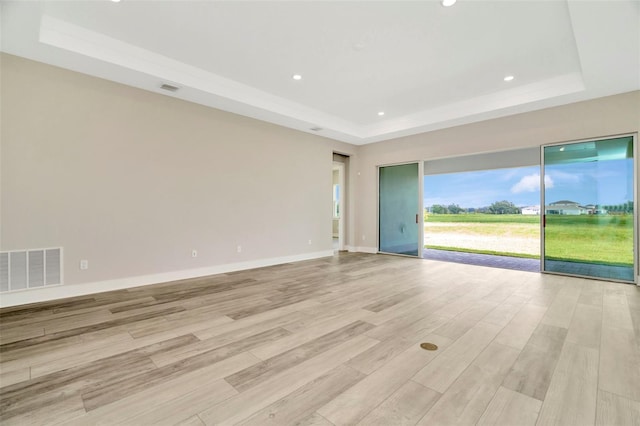10714 Torchwood Sea Way, San Antonio, FL 33576 - empty room featuring light wood-style flooring, a raised ceiling, visible vents, and baseboards