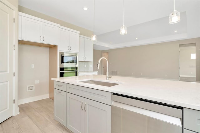 10714 Torchwood Sea Way, San Antonio, FL 33576 - kitchen with a tray ceiling, pendant lighting, white cabinetry, a sink, and dishwasher