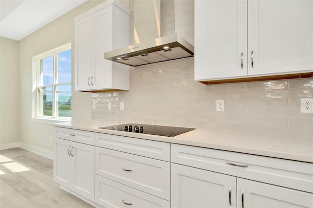 10714 Torchwood Sea Way, San Antonio, FL 33576 - kitchen with tasteful backsplash, baseboards, white cabinets, black electric cooktop, and extractor fan