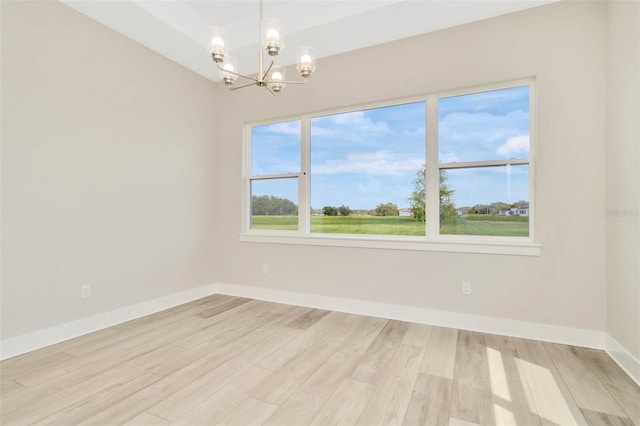 10714 Torchwood Sea Way, San Antonio, FL 33576 - unfurnished room featuring light wood finished floors, an inviting chandelier, and baseboards