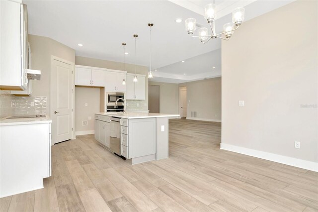 10714 Torchwood Sea Way, San Antonio, FL 33576 - kitchen with a center island with sink, white cabinets, stainless steel appliances, light countertops, and pendant lighting