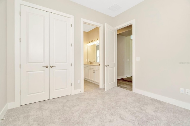 10714 Torchwood Sea Way, San Antonio, FL 33576 - unfurnished bedroom with a closet, light colored carpet, connected bathroom, and baseboards