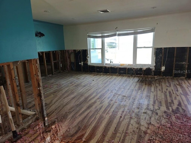 empty room featuring wood finished floors and visible vents