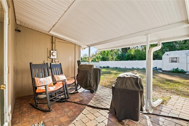 view of patio featuring a fenced backyard, a shed, area for grilling, and an outbuilding