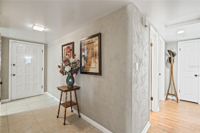 foyer entrance with light wood-style floors and baseboards