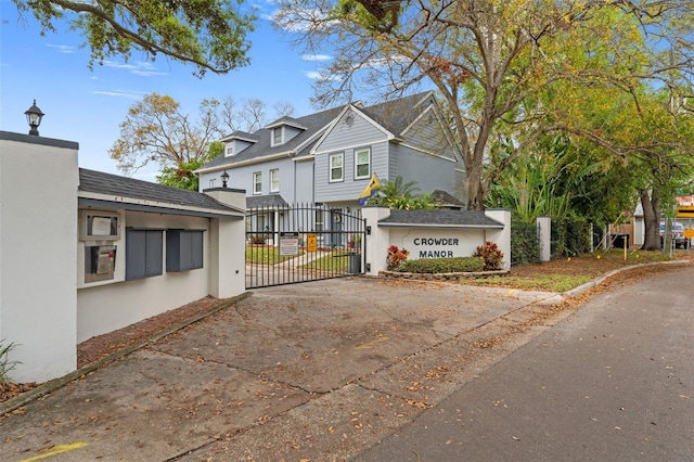 exterior space with a gate, fence, and stucco siding