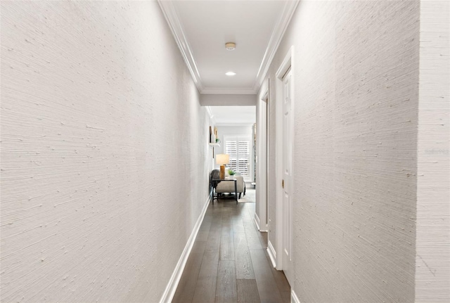 hall with a textured wall, ornamental molding, dark wood-type flooring, and baseboards