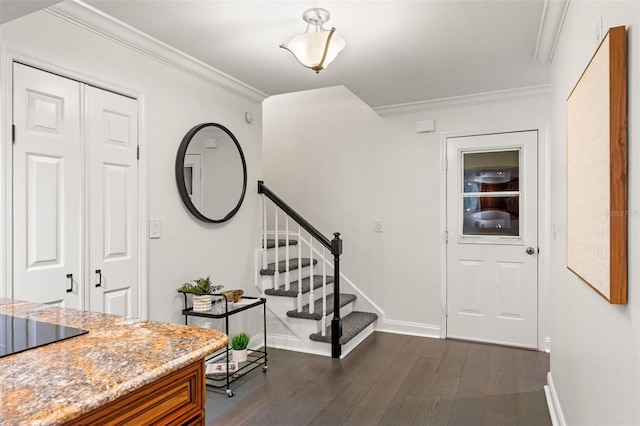 foyer entrance with stairs, ornamental molding, dark wood finished floors, and baseboards