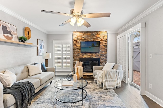 living area featuring ornamental molding, a fireplace, wood finished floors, and baseboards